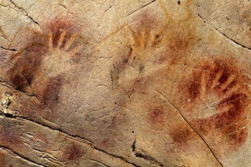 Les mains réalisées au pochoir avec de la poudre d'ocre de la grotte d'El Castillo en Espagne <br />ont été réalisées il y a au moins 37 300 ans.