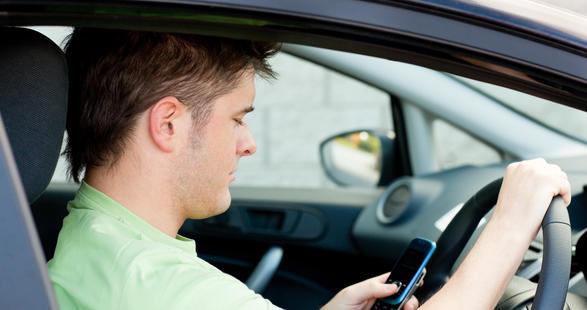 man using a mobile while driving