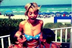 Rita Ora se laisse embrasser les seins à la plage ! 