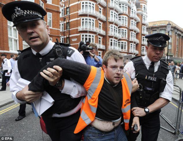 A supporter of Julian Assange is removed by police outside the Ecuador embassy as the crowd grew. It is not known whether he was arrested.