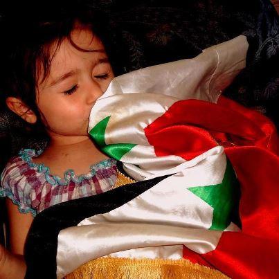 Une fillette syrienne embrassant son drapeau
