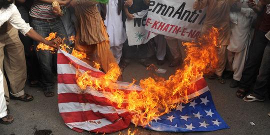 Des manifestants contre le film islamophobe brulent un drapeau américain à Karachi au Pakistan, le 15 septembre.