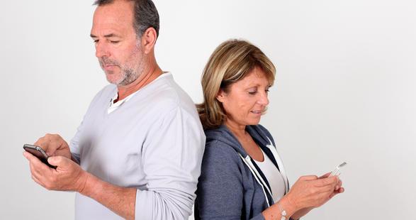 un couple de baby-boomers avec leurs smartphones