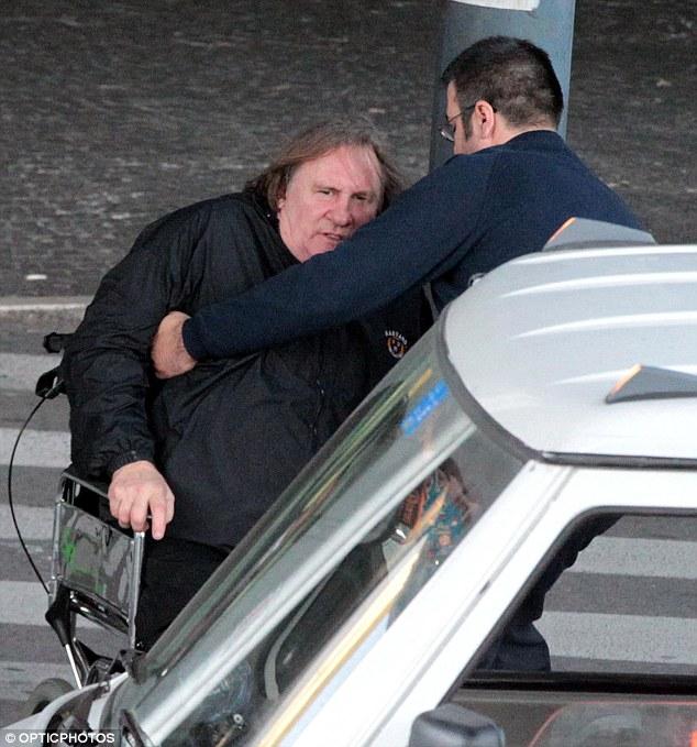 Helping hand: The actor has to be helped out of his wheelchair and into his car, unable to get up on his own