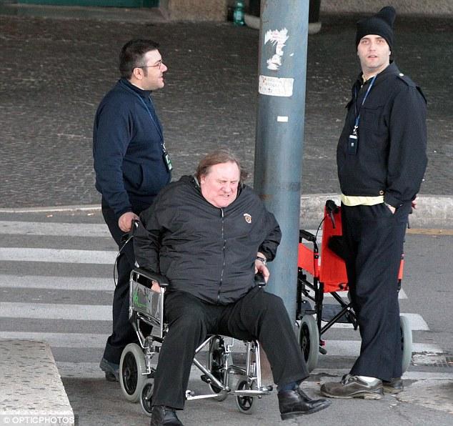 Struggling: Gerard can't seem to lift himself out of the wheelchair after it's pushed to his car