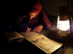 Une jeune Afghane étudie à la lueur d'une lampe à l'huile. Photo CC Flickr camafghanistancam.