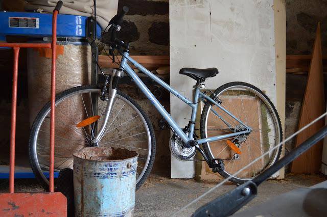 Un vélo et du bois de chauffe dans la grange