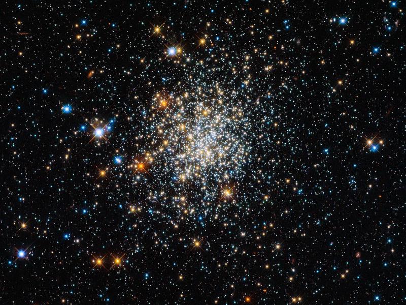Globular  clusters are roughly spherical collections of extremely old stars, and  around 150 of them are scattered around our galaxy. Hubble is one of the  best telescopes for studying these, as its extremely high resolution  lets astronomers see individual stars, even in the crowded core. The  clusters all look very similar, and in Hubbleâ€™s images it can be quite  hard to tell them apart â€“ and they all look much like NGC 411, pictured  here. And  yet appearances can be deceptive: NGC 411 is in fact not a globular  cluster, and its stars are not old. It isnâ€™t even in the Milky Way. NGC  411 is classified as an open cluster. Less tightly bound than a  globular cluster, the stars in open clusters tend to drift apart over  time as they age, whereas globulars have survived for well over 10  billion years of galactic history. NGC 411 is a relative youngster â€” not  much more than a tenth of this age. Far from being a relic of the early  years of the Universe, the stars in NGC 411 are in fact a fraction of  the age of the Sun. The  stars in NGC 411 are all roughly the same age, having formed in one go  from one cloud of gas. But they are not all the same size. Hubbleâ€™s  image shows a wide range of colours and brightnesses in the clusterâ€™s  stars. These tell astronomers many facts about the stars, including  their mass, temperature and evolutionary phase. Blue stars, for  instance, have higher surface temperatures than red ones. The  image is a composite produced from ultraviolet, visible and infrared  observations made by Hubbleâ€™s Wide Field Camera 3. This filter set lets  the telescope â€œseeâ€� colours slightly further beyond red and the violet  ends of the spectrum.
