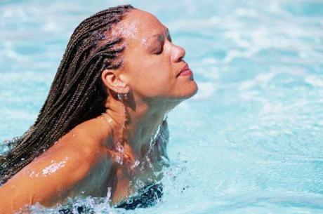 Femme noire avec des tresses rastas dans une piscine