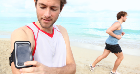 2 men running on the beach with self-tracking devices
