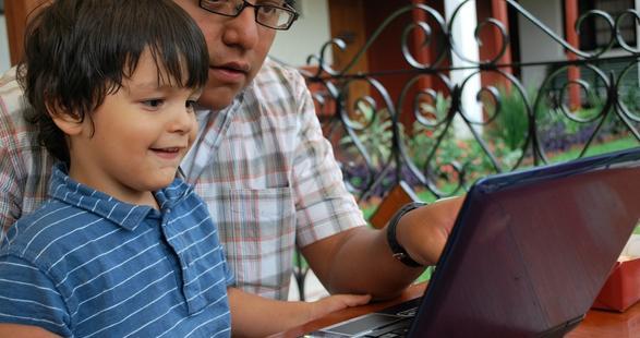 hispanic dad and his son on a laptop