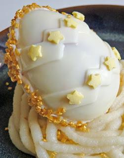 Oeuf de pâques au chocolat blanc, à la mousse de framboise et financier pistache sur nid en pâte d'amande