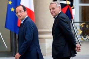 French President Hollande walks next to Prime Minister Ayrault at the Elysee Palace