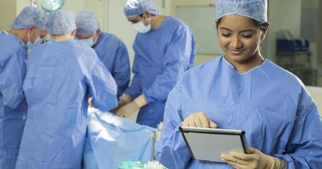 médecin en salle d'opération tenant un iPad