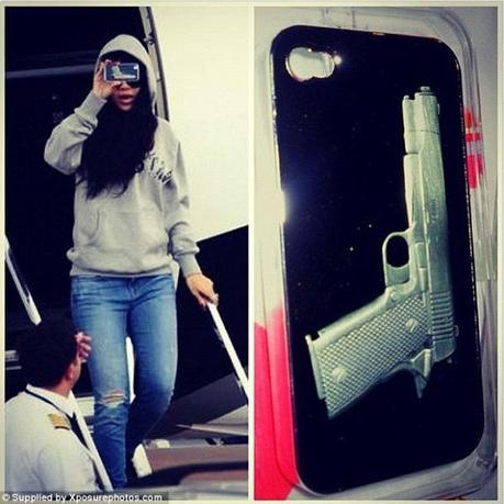 Rihanna montrant que la coque de son téléphone portable représente une arme à feu (été 2012).