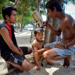 Upil coupe les cheveux du fils d'Adhi, Andra (Tomken, îles Togian, Sulawesi Centre, Indonésie)