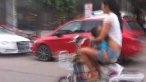 Chinoise allaitant son nourrisson sur scooter