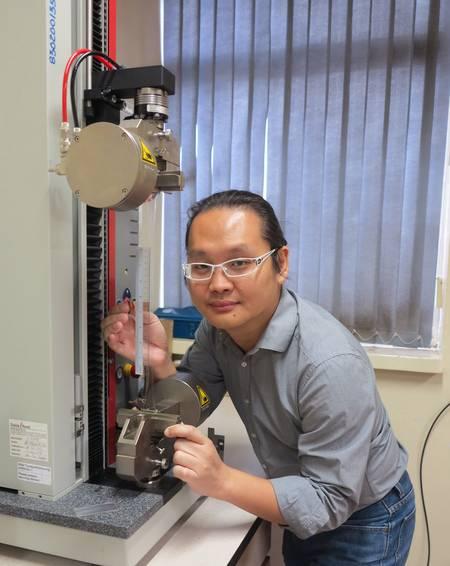 Le professeur Adrian Koh de l’Université nationale de Singapour. Il pose devant la machine qui sert à préétirer les muscles artificiels qui peuvent atteindre jusqu’à 5 fois leur longueur initiale.