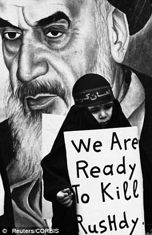 A girl carries a placard vowing to kill Rushdie during a pro-Iranian demonstration in Beirut in 1989. Behind is a poster of Ayatollah Khomeini, who ordered the fatwa 