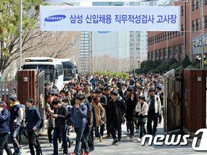 A gauche, les candidats sortant du lieu d'examen. A droite, les manuels.