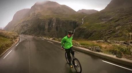 Eskil Ronningsbakken fait du vélo assis sur le guidon et dos à la route