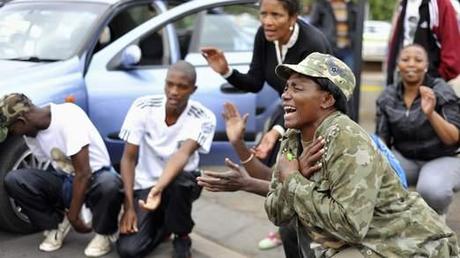 Les gens réagissent lors de la collecte de deuil sur Vilakazi Street, à Soweto, où l'ancien président sud-africain Nelson Mandela résidait quand il vivait dans le canton