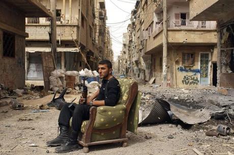 Un membre de l'armée civile syrienne assis au milieu des décombres.