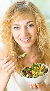 Young woman with vegetable salad at home