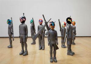 Mambrú. 2005 Instalación.  Talla en madera de cedro de la figura de niños de 8 a 12 años al tamaño real. Recubierto de laminas de plomo. Máscaras de  