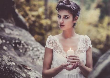 robe de mariée romantique en dentelle de calaiss femme tenant une bougie dans une foret, mystique