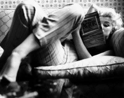 photo marilyn monroe allongée dans un sofa canapé vintage avec un pantalon cigarette des années 60 lisant un livre de l'acteur studio