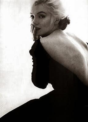 Photographie de Marilyn monroe noi et blanc, blonde platine, avec une robe noire dos décolleté, image triste