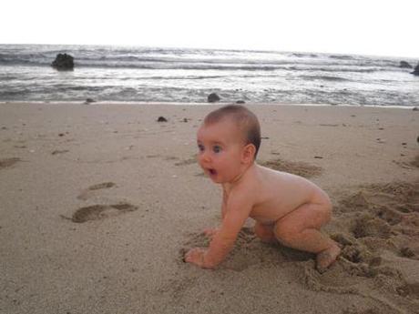 Bébé, à l'aise à la plage avec le sable et la mer...