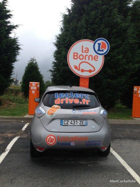 Photo num. 8. Une voiture électrique devant la borne ( de charge). Elles sont à louer 