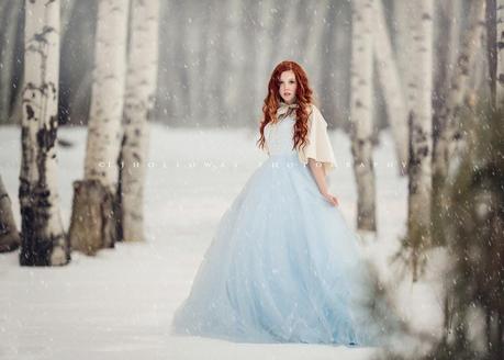 photo de Lisa Holloway représentant une jeune femme en robe blanche dans une forêt enneigée  