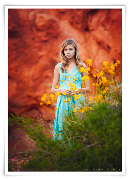 photo de Lisa Holloway représentant une jeune fille blonde derrière des fleurs jaunes 