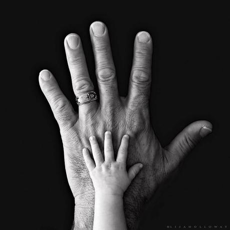 photo de Lisa Holloway représentant une main d'enfant posée sur une main d'homme en noir et blanc