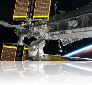 Aperçu de deux des panneaux solaires doubles de l'ISS. On y voit également l'astronaute Steve Bowen, de la mission STS-126. Crédit image : NASA 