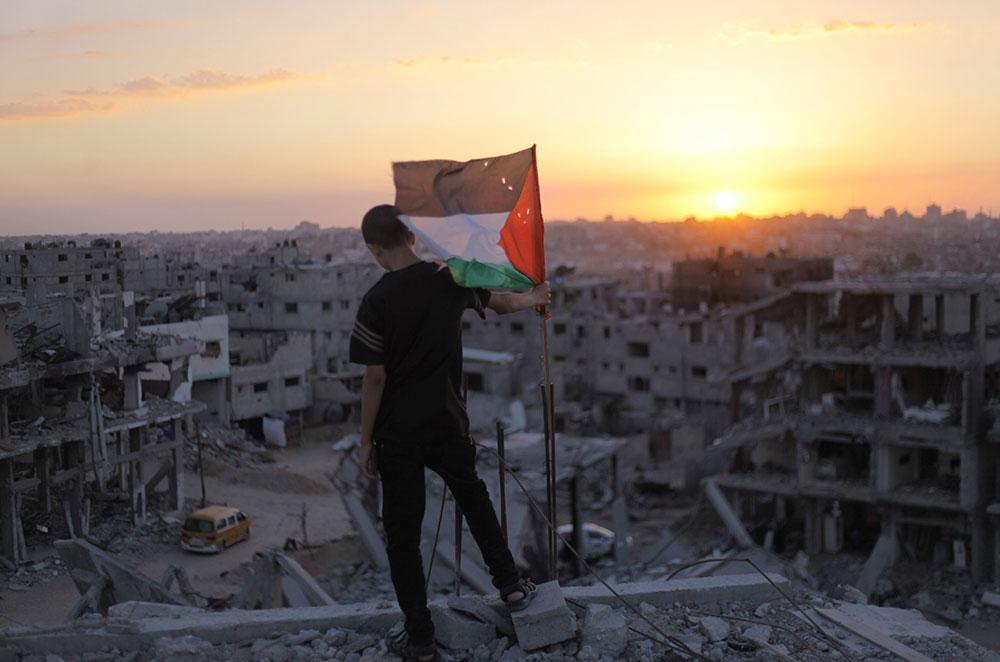 Un jeune palestinien face à sa maison en ruines, suite aux attaques israéliennes, le 19 septembre 2014. 