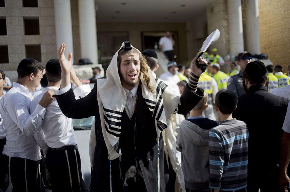 Un juif ultra-orthodoxe prie après l'attentat contre une synagogue, le 18 novembre 2014. 