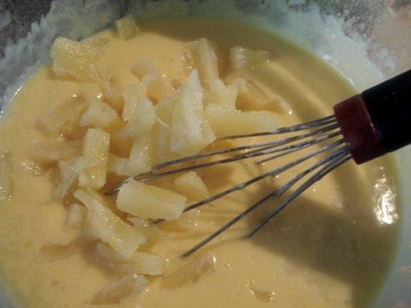 Dans un saladier ou un cul de poule battre les œufs avec le sucre, ajoutez la farine, la levure, le sucre vanillé puis le beurre fondu  . Coupez les 4 tranches d’ananas restantes en petits dés et mélangez à la préparation précédente.