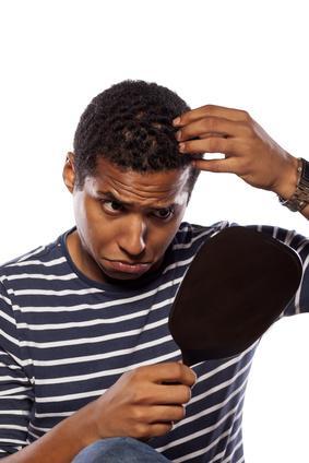 concerned dark-skinned young man settles himself in the mirror