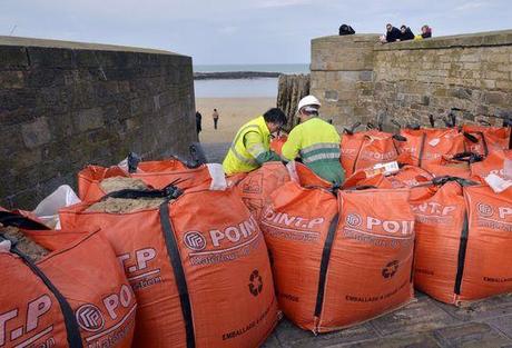 Des employés municipaux installent des sacs de sable près de Saint-Malo, en prévision des grandes marées, le 19 février.