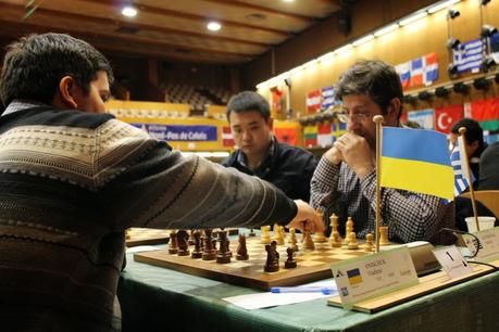 Lors de la ronde 8, Vasilios Kotronias avec les Blancs perd contre Vladimir Onischuk sous les yeux de Li Chao - Photo © Chess & Strategy