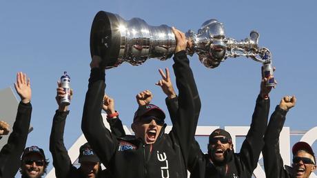 Skipper James Spithill lifts the America's Cup with members of the Oracle Team USA after winning the overall title of the 34th America's Cup yacht sailing race over Emirates Team New Zealand in San Francisco