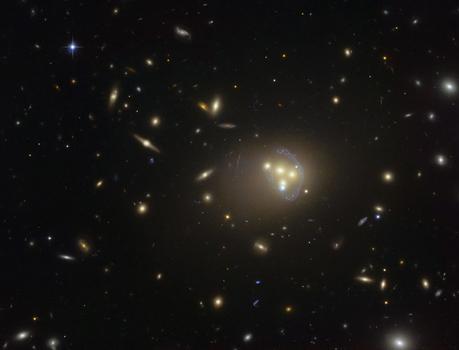 Cette image acquise par le Télescope Spatial Hubble du consortium NASA/ESA montre le riche amas galactique Abell 3827. Les étranges structures de couleur bleue qui entourent les galaxies centrales constituent des vues magnifiées, par effet de lentille gravitationnelle, d'une galaxie plus lointaine située derrière l'amas. Des observations de la fusion des quatre galaxies centrales ont démontré que la matière noire entourant l'une des galaxies ne suit pas le mouvement de la galaxie elle-même. Ce résultat permet d'envisager la possible existence d'interactions matière noire – matière noire de nature inconnue