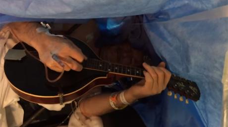 Un homme joue de la mandoline pendant une opération du cerveau