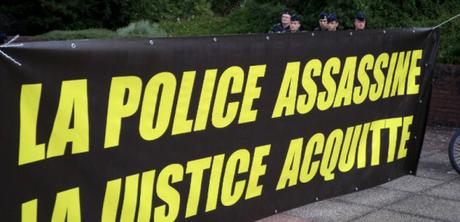 Policemen stand behind a banner reading 