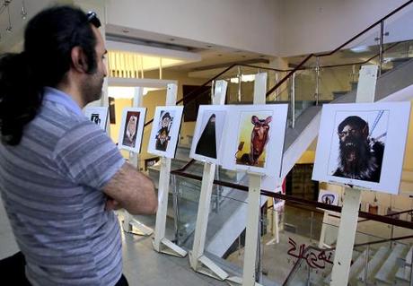 Un Iranien regarde des caricatures sur le groupe Etat islamique, à une exposition à Téhéran, le 31 mai 2015 © Atta Kenare AFP