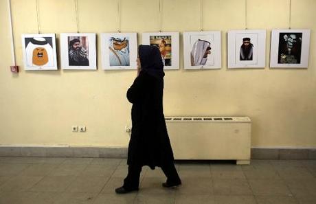 Une Iranienne passe devant des caricatures sur le groupe Etat islamique, à une exposition à Téhéran, le 31 mai 2015 © Atta Kenare AFP